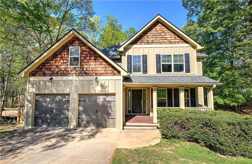 Craftsman-style home with board and batten siding, a porch, and concrete driveway