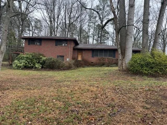 Split level home featuring brick siding and a front lawn