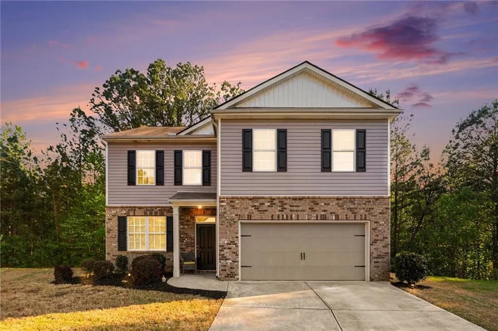 View of front of home featuring brick siding, driveway, a garage, and a lawn