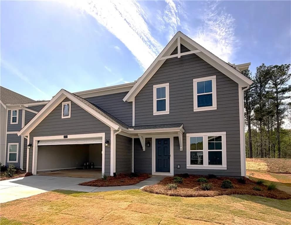 View of front of home featuring a front yard, driveway, and a garage