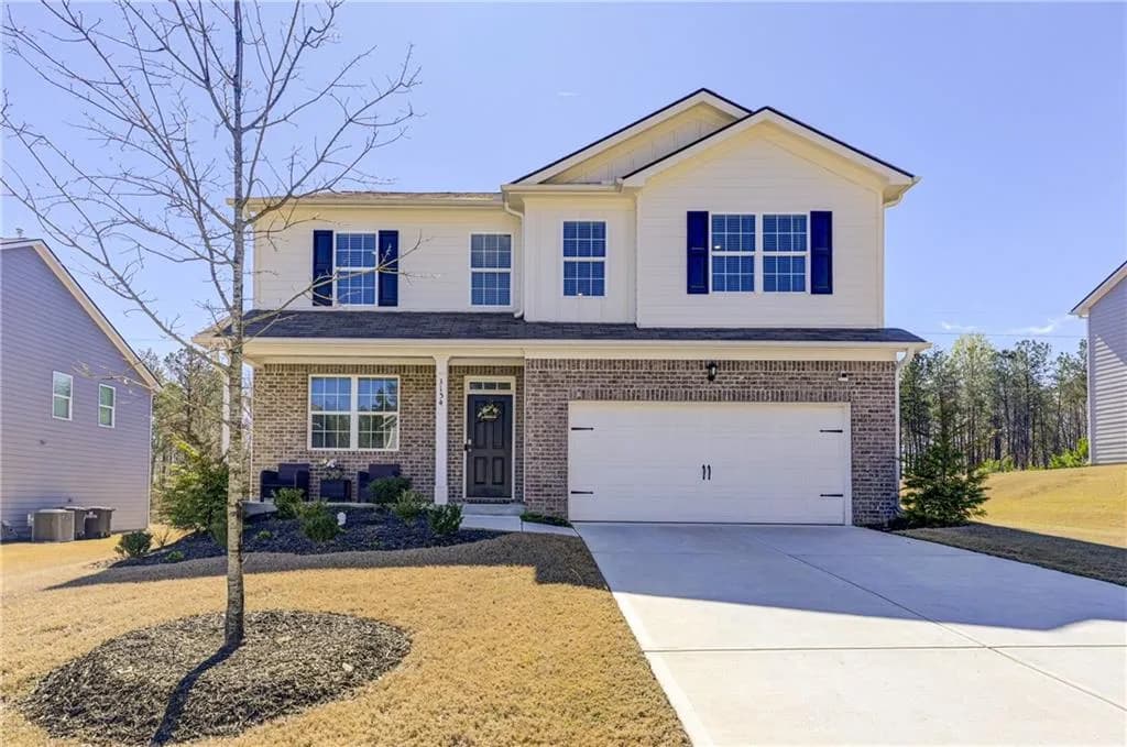 Traditional home featuring concrete driveway, covered porch, and brick siding