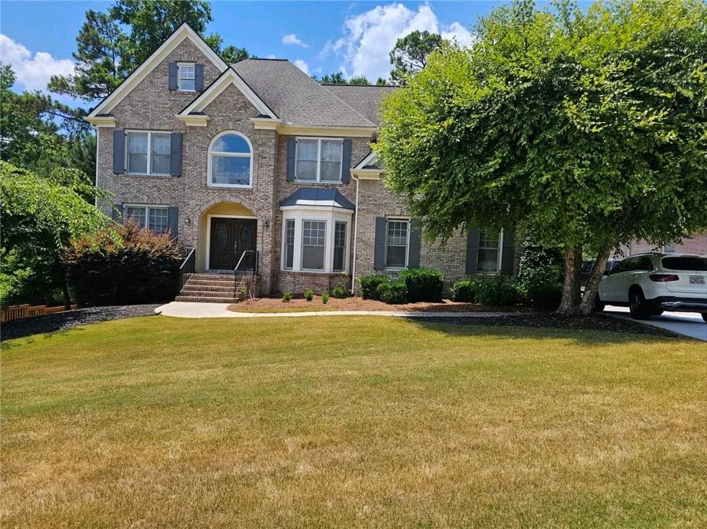 View of front of home featuring brick siding and a front yard