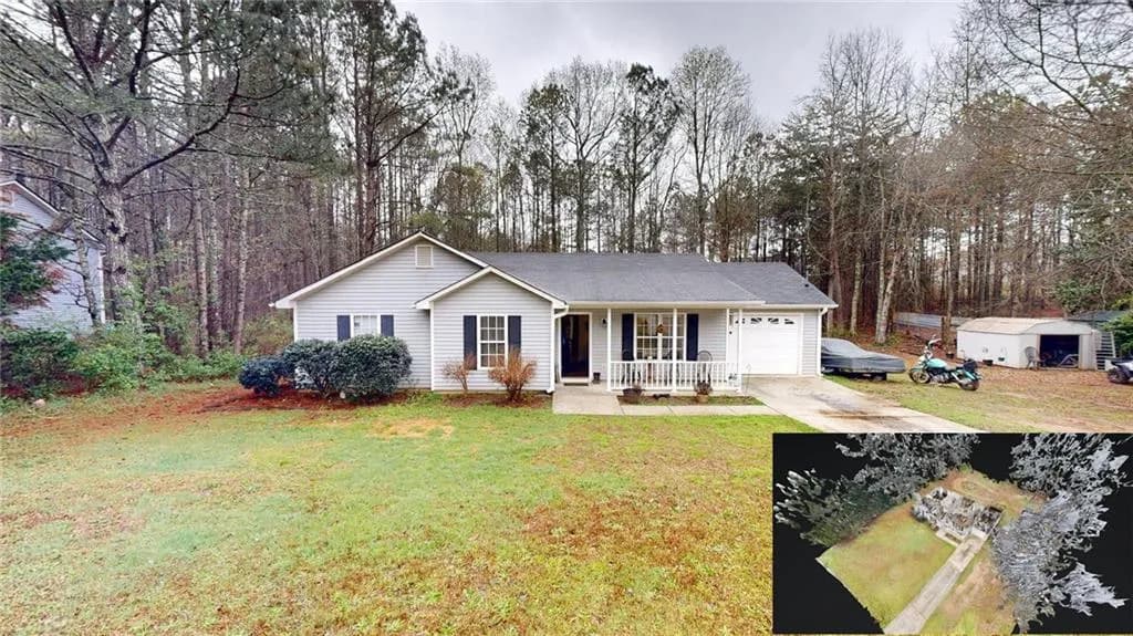Single story home with a porch, an attached garage, a front lawn, driveway, and view of wooded area