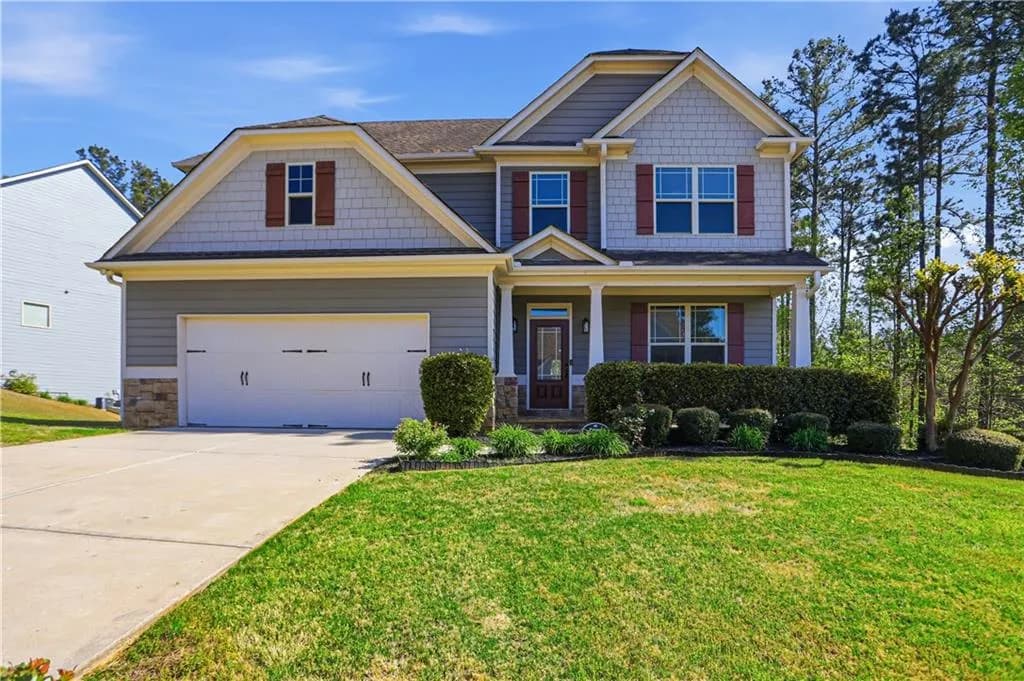 Craftsman inspired home with a porch, concrete driveway, stone siding, and a front yard