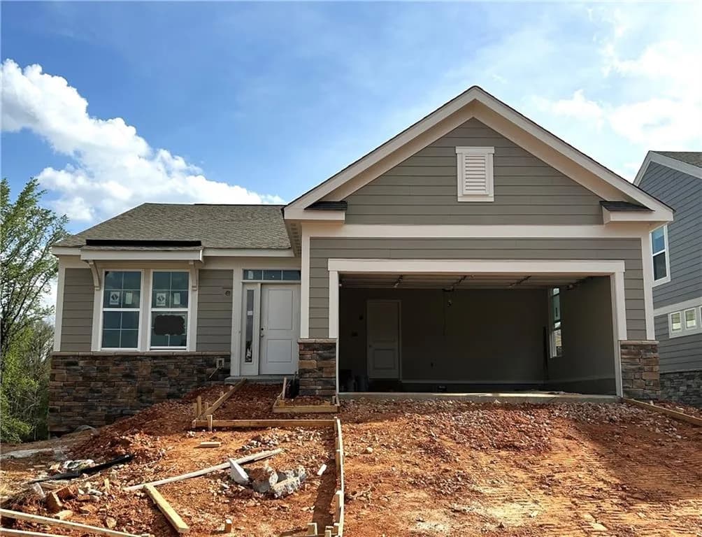 Craftsman inspired home featuring stone siding, dirt driveway, a shingled roof, and a garage