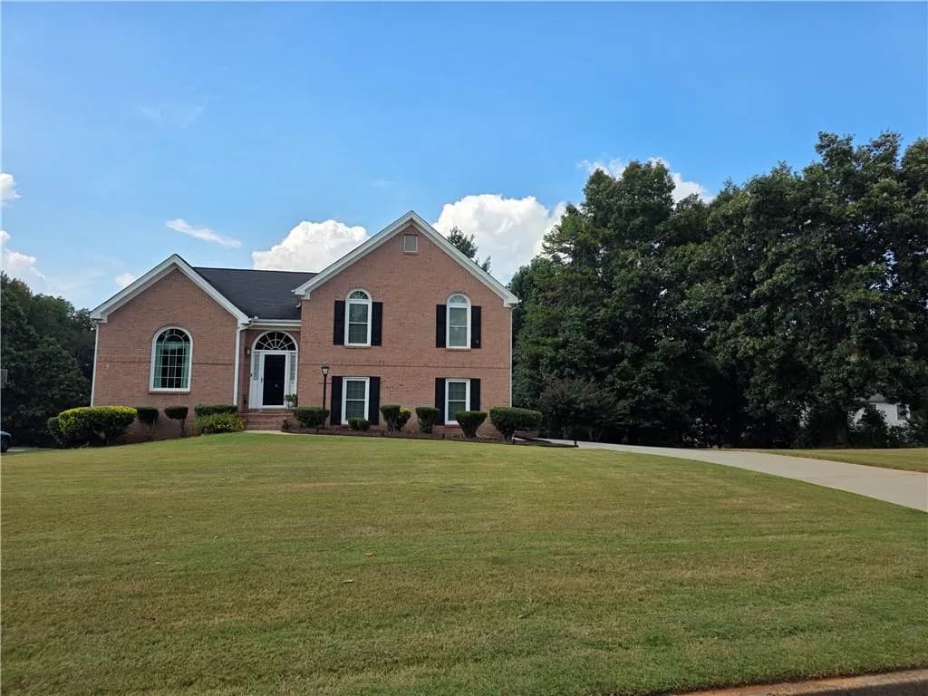 View of front of property featuring a front yard and brick siding