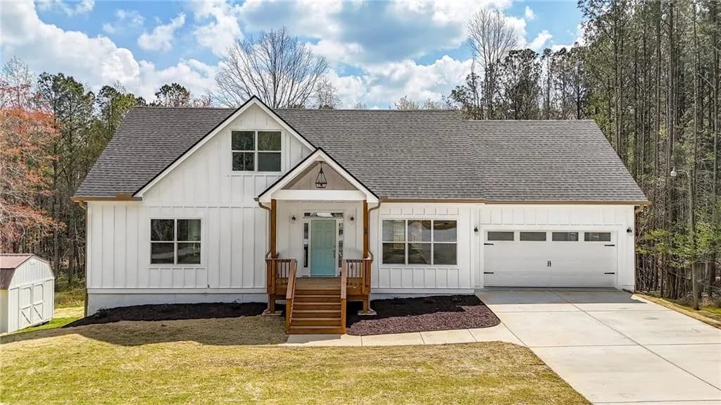 Modern farmhouse style home featuring board and batten siding, roof with shingles, driveway, a front lawn, and a garage