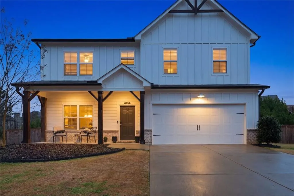 View of front of home featuring a porch, board and batten siding, concrete driveway, and an attached garage