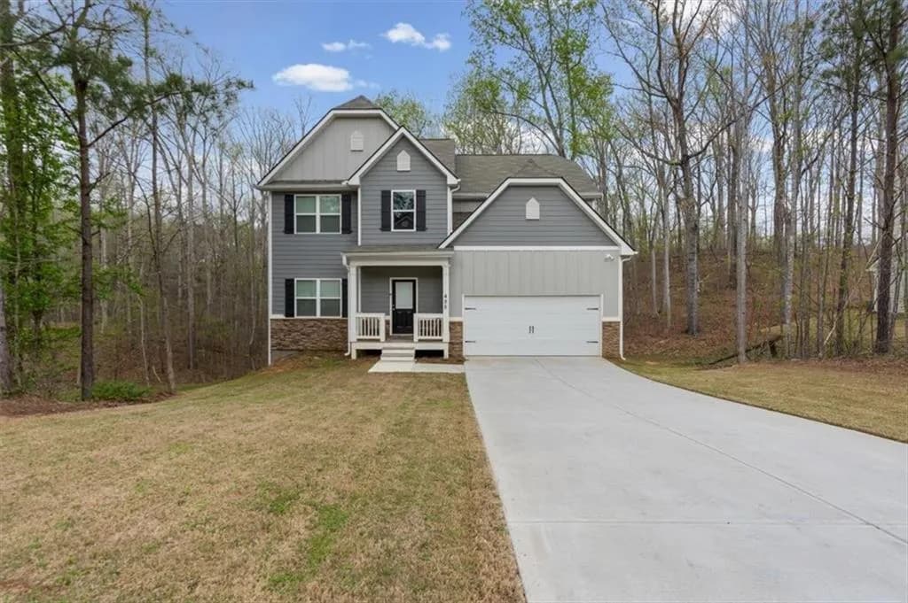 Craftsman house with board and batten siding, a porch, stone siding, and driveway