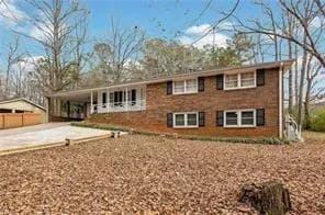 View of front facade featuring concrete driveway and a carport