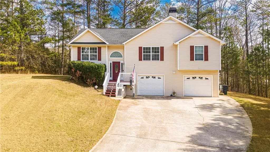 Raised ranch with a front yard, concrete driveway, a shingled roof, a garage, and a chimney
