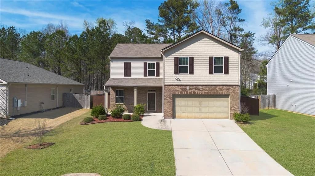 Traditional-style house featuring covered porch, driveway, brick siding, and an attached garage