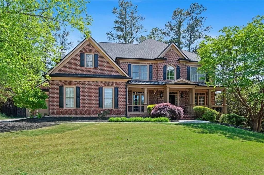 Front Exterior – Classic brick façade with charming architectural details, complemented by manicured landscaping and mature trees that enhance curb appeal.