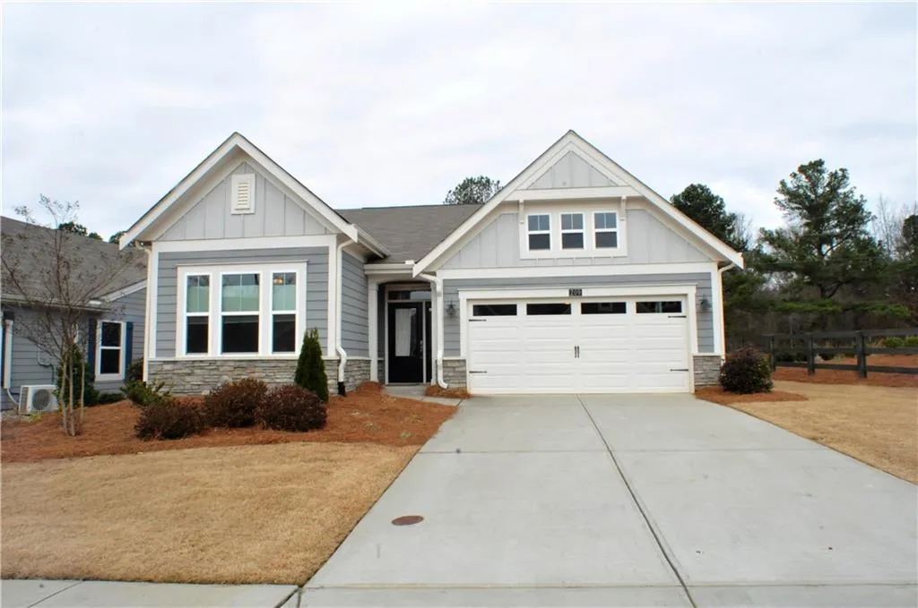 Craftsman inspired home with board and batten siding, stone siding, concrete driveway, and a garage