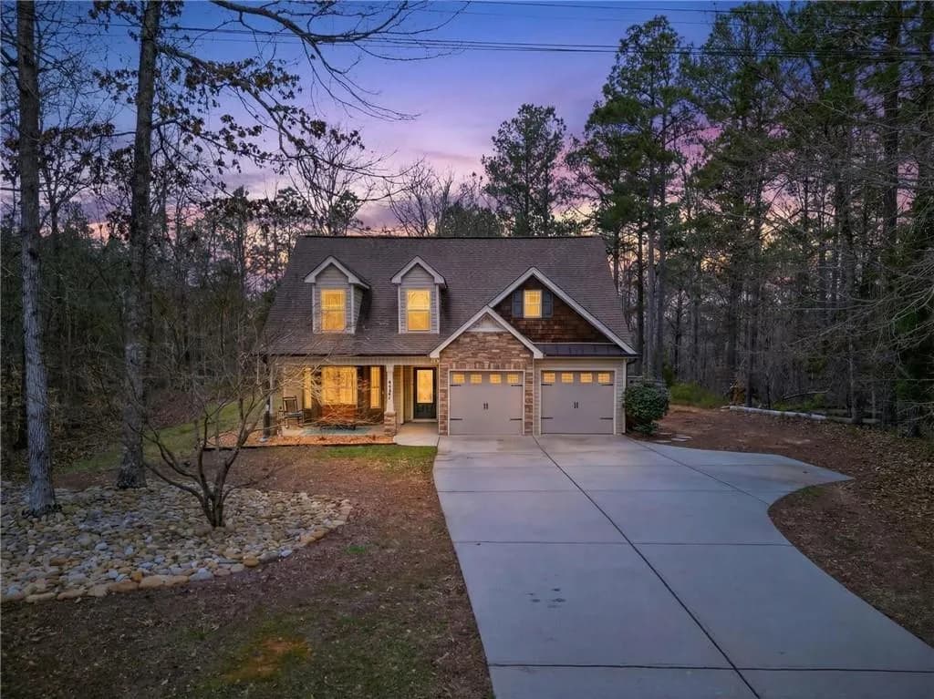View of front facade with a porch, driveway, and a garage