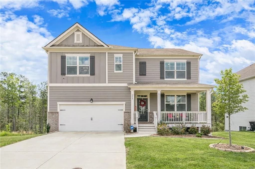 Craftsman house featuring board and batten siding, a porch, a garage, a front lawn, and driveway