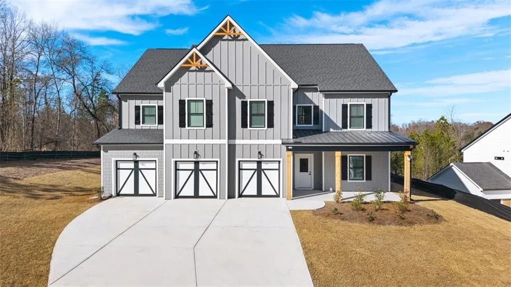 Modern farmhouse style home featuring board and batten siding, an attached garage, driveway, a porch, and a front yard