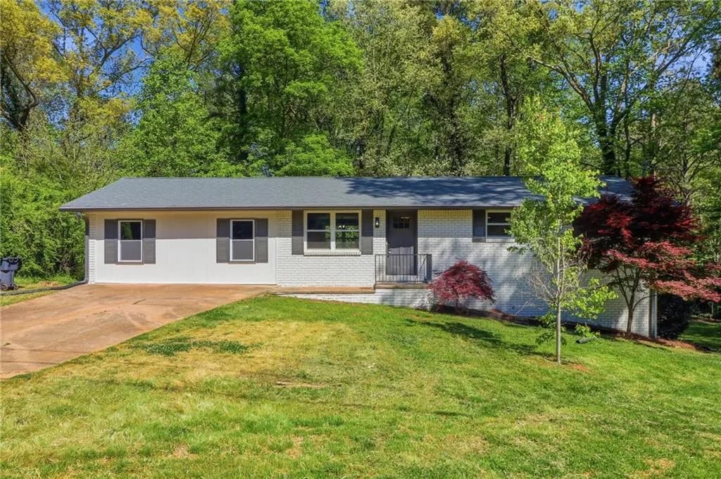 Ranch-style home with a front lawn, brick siding, and covered porch
