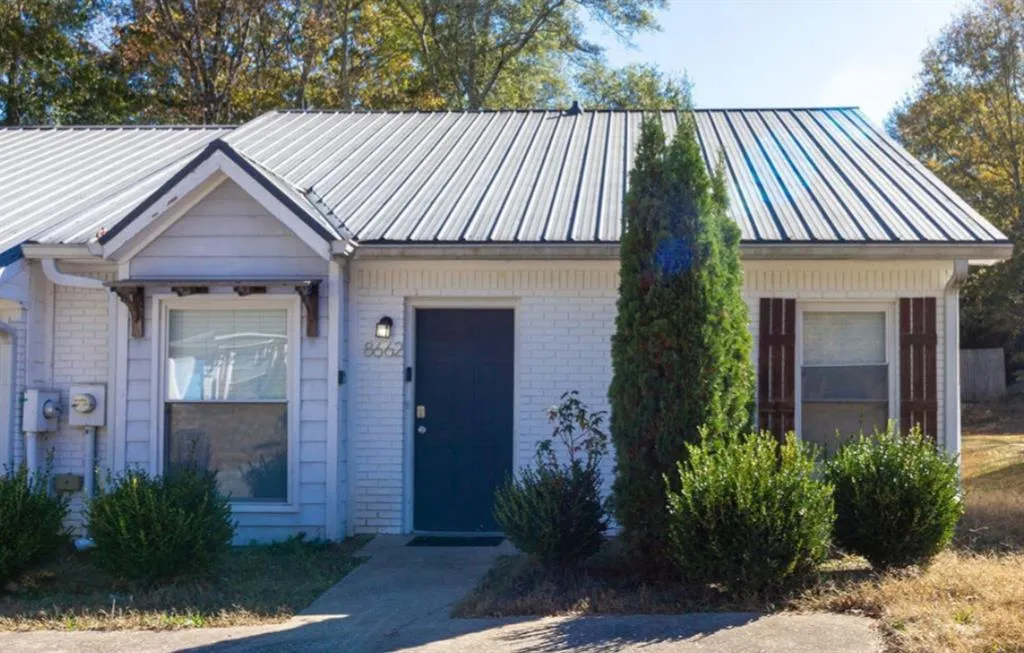 View of front of house with brick siding and a metal roof