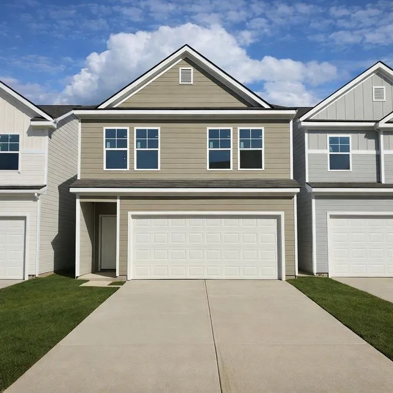 View of front facade featuring board and batten siding, concrete driveway, and a garage