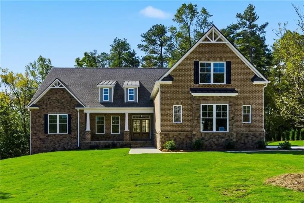 Craftsman house featuring a porch, brick siding, a front lawn, and stone siding