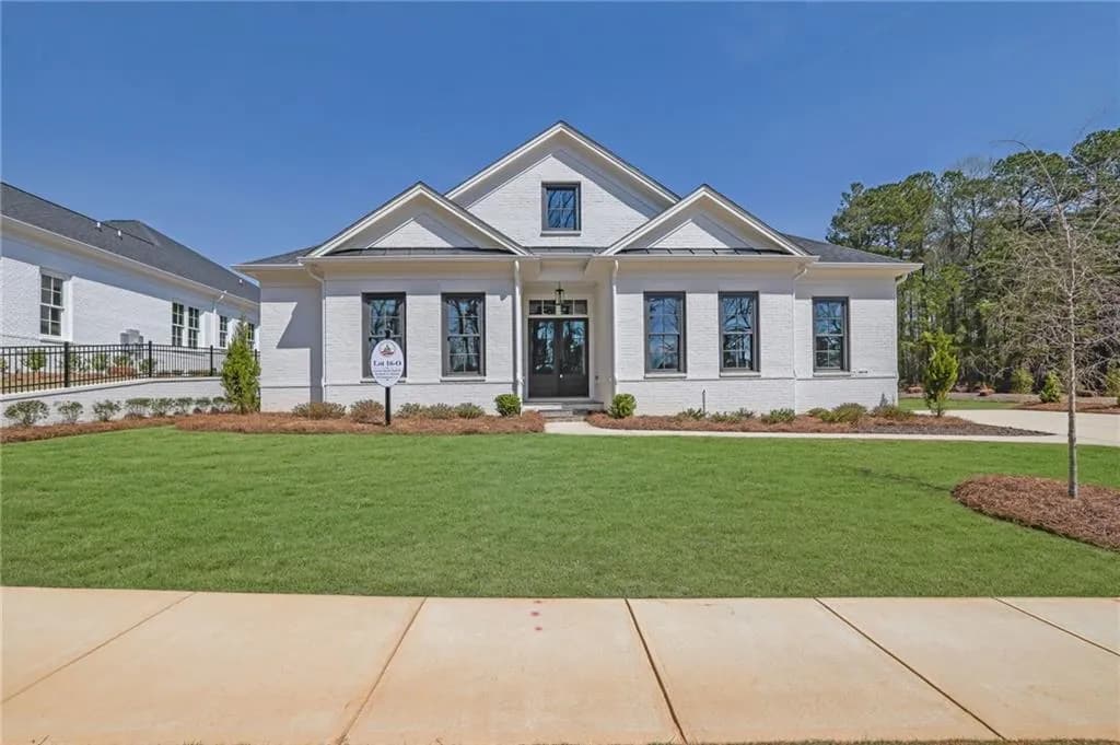 View of front of house featuring brick siding, fence, and a front lawn