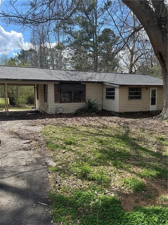 Single story home featuring an attached carport, driveway, and a front lawn