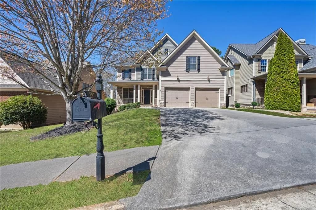 Traditional-style home featuring a porch, a garage, concrete driveway, and a front lawn
