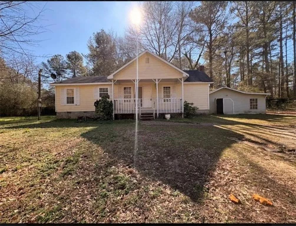 View of front of home with covered porch, crawl space, and a front yard