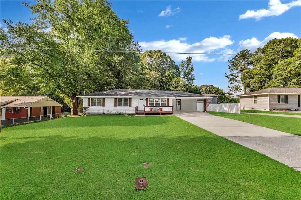 Ranch-style home with driveway, an attached carport, a wooden deck, and crawl space