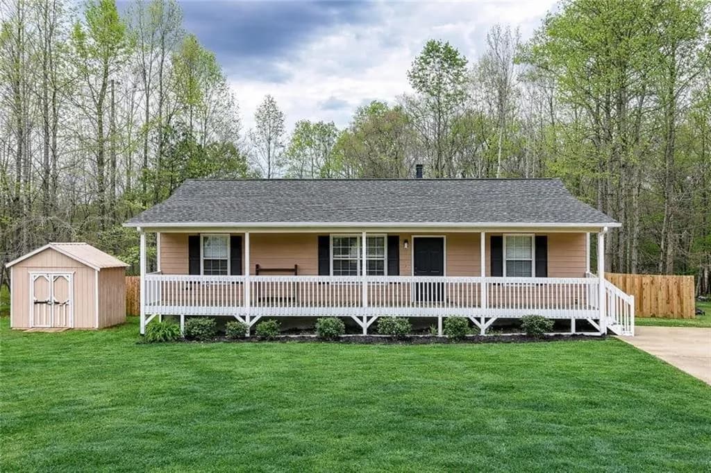 View of front of house with a porch, a storage shed, and a shingled rooff Edited