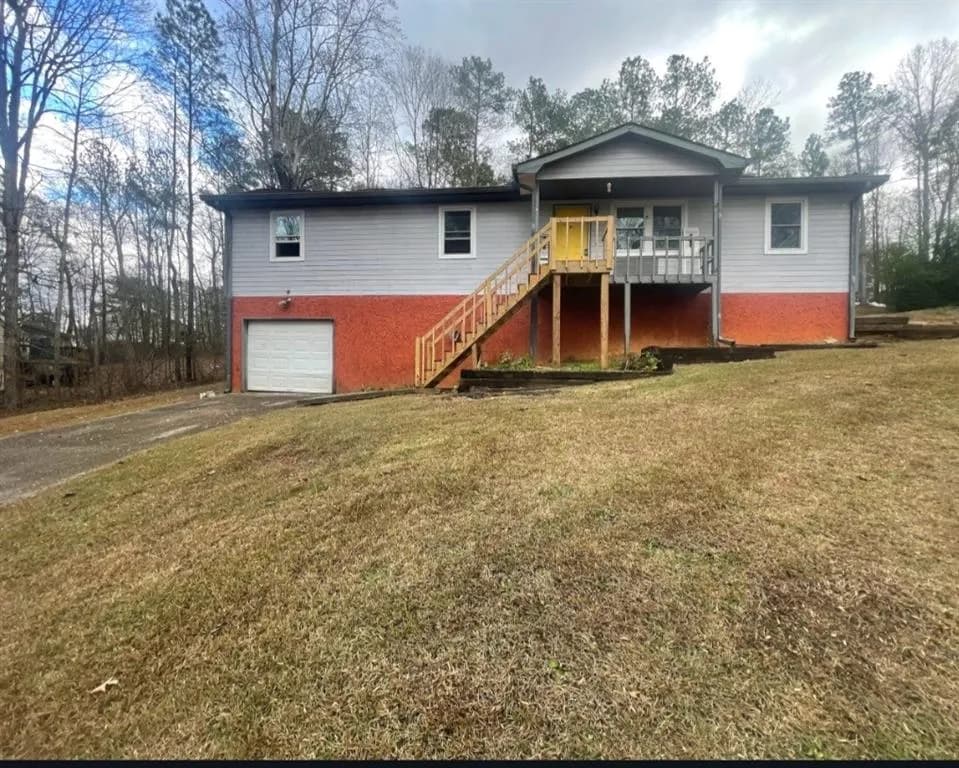Single story home featuring a garage, brick siding, and a front lawn