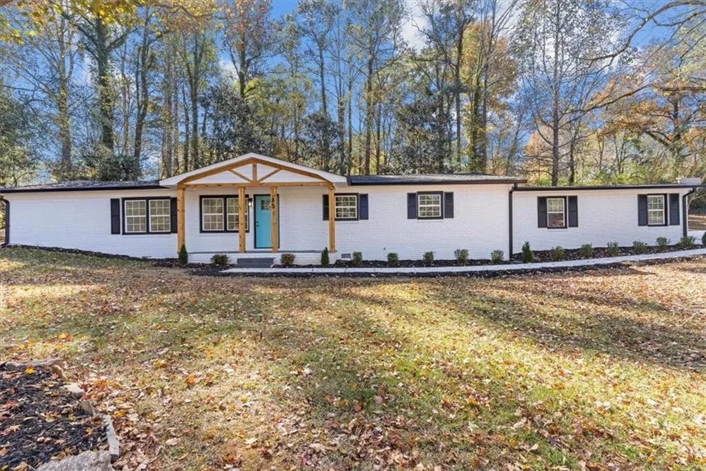 Ranch-style home featuring brick siding, a porch, and a front yard