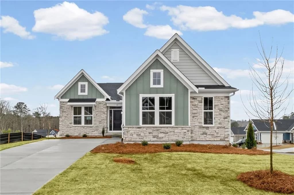 Craftsman house with board and batten siding, stone siding, and concrete driveway