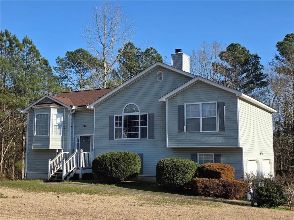 Split foyer home featuring a chimney and a front lawn