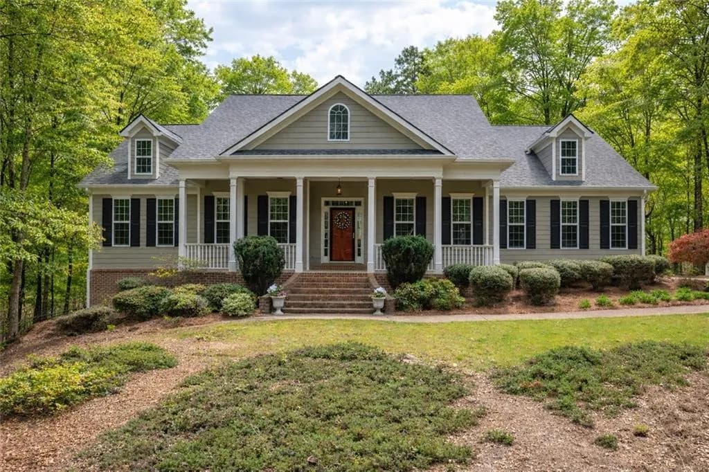 View of front of property with roof with shingles, covered porch, and a front lawn