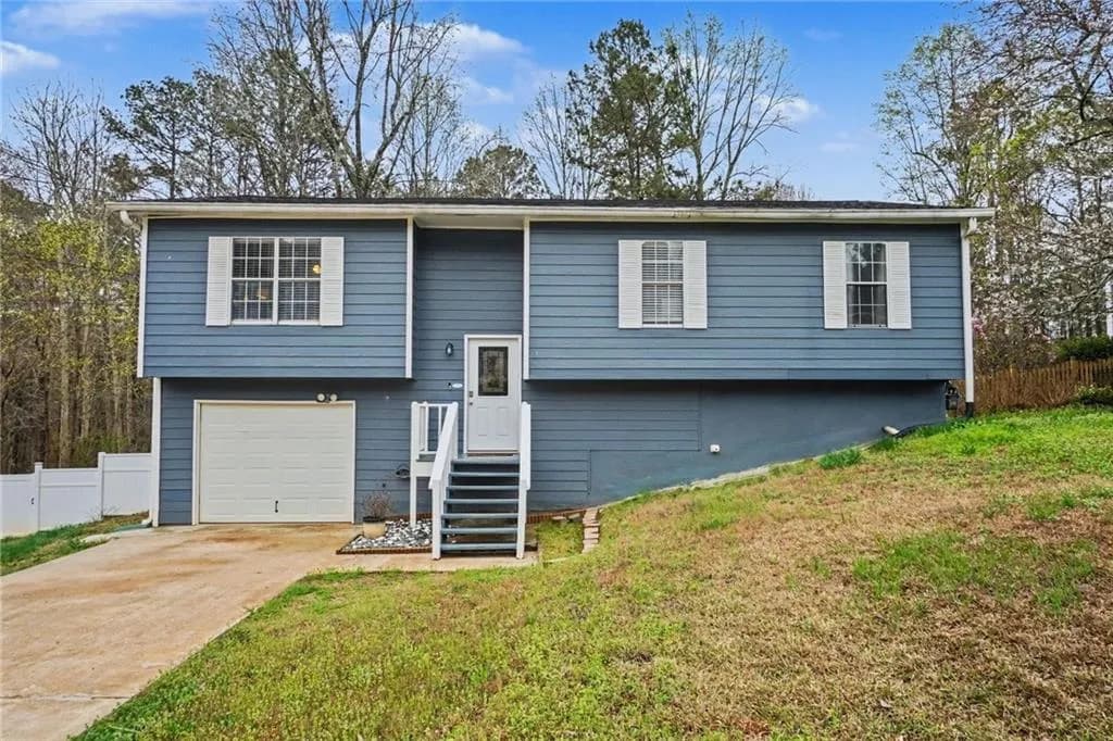Raised ranch with driveway and a garage
