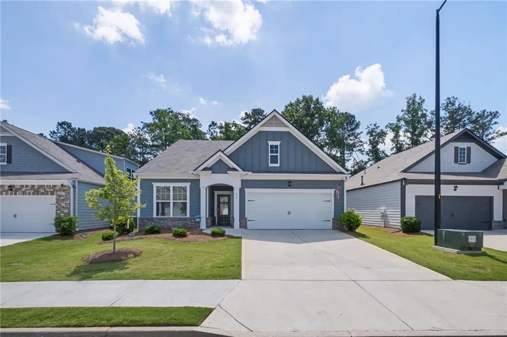 Craftsman inspired home featuring board and batten siding, a garage, concrete driveway, and a front yard