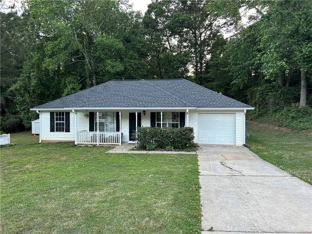 Ranch-style residence featuring white siding, a dark shingle roof, a single-car garage, and a covered front porch with white railings