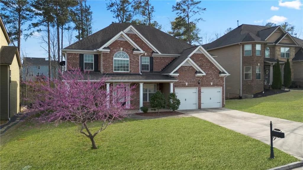 View of front of home with a front lawn, brick siding, driveway, a porch, and a shingled roof