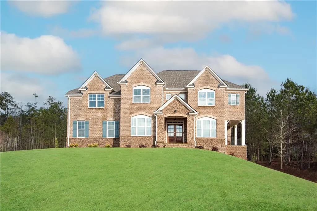 The property features a brick exterior, a gabled roof, and an expansive front lawn