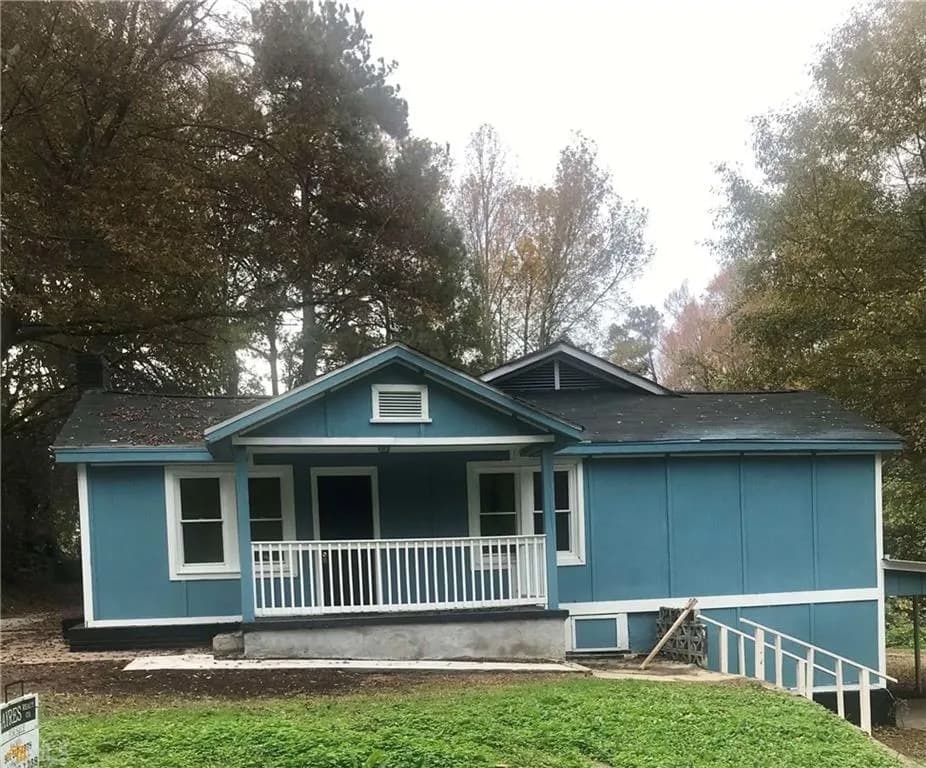 View of front of property featuring a porch and a front yard