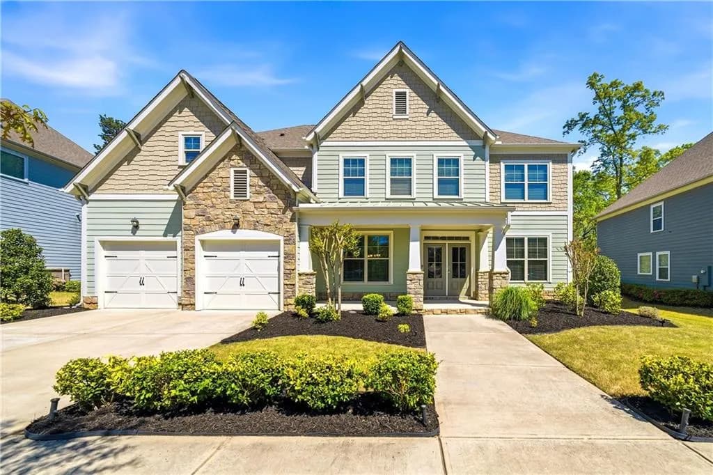 Craftsman inspired home featuring a porch, stone siding, driveway, a standing seam roof, and an attached garage