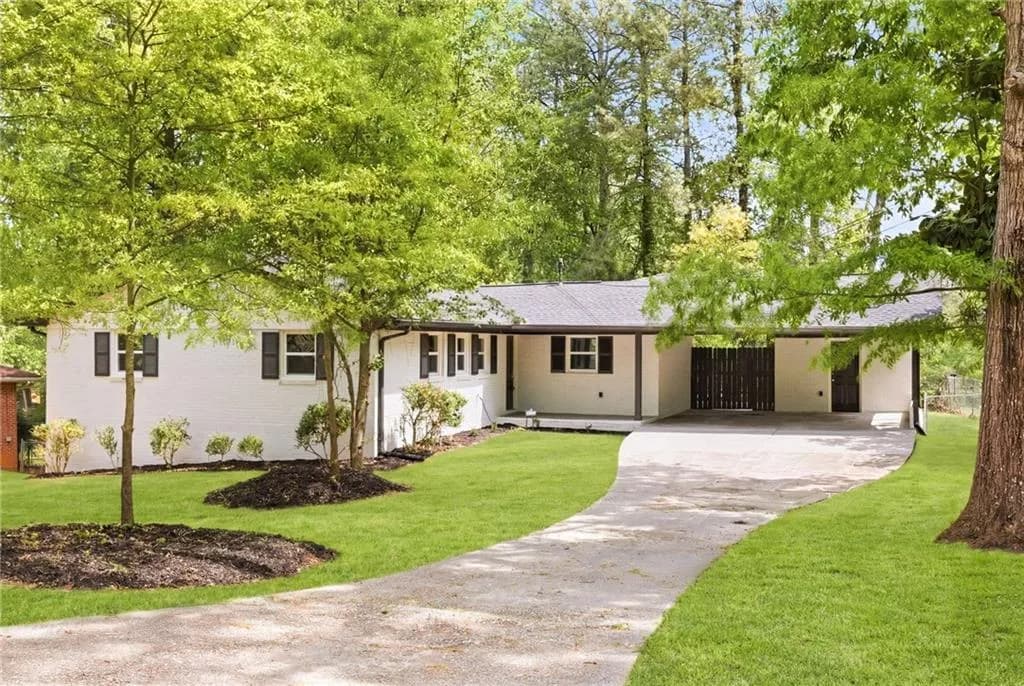 Ranch-style house with a carport, concrete driveway, brick siding, and roof with shingles