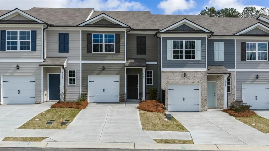 Craftsman-style home featuring a shingled roof, concrete driveway, brick siding, and an attached garage