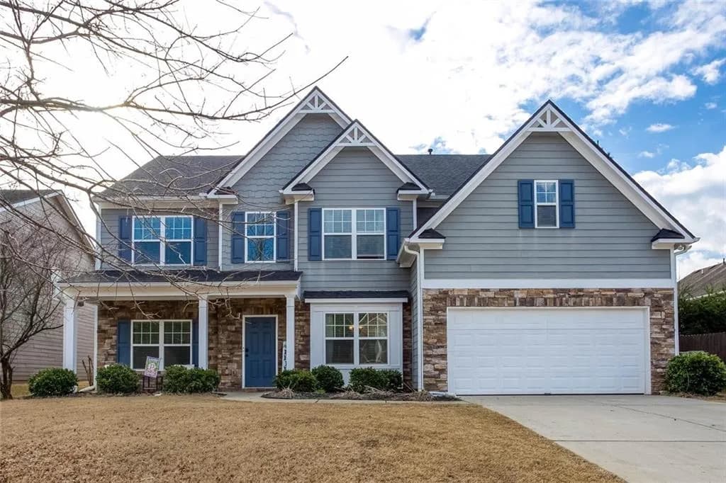 Craftsman house featuring a porch, stone siding, and concrete driveway