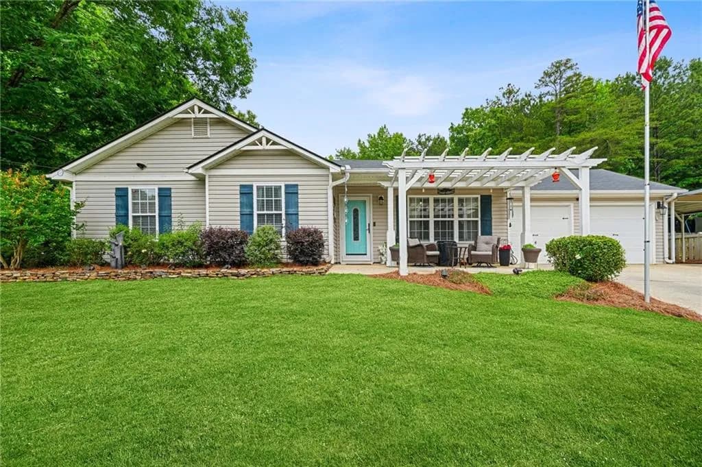 Front of ranch-style residence featuring a two-car garage, and additional carport