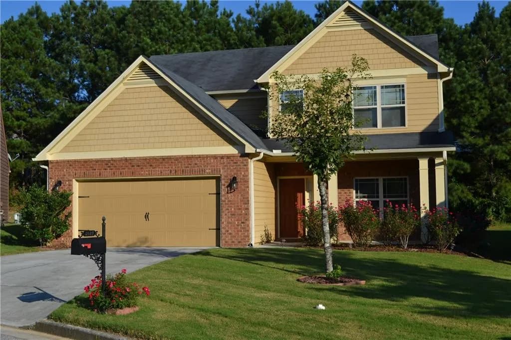 Craftsman-style home with driveway, a porch, a garage, a front lawn, and brick siding