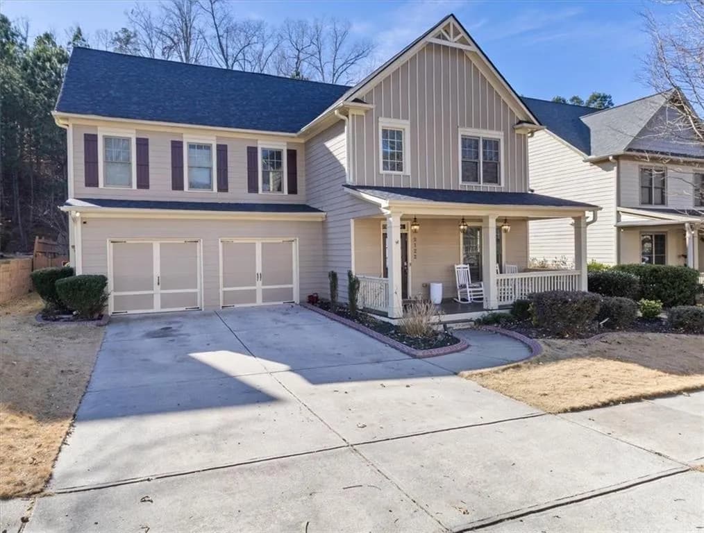 View of front facade with covered porch, concrete driveway, board and batten siding, a garage, and roof with shingles