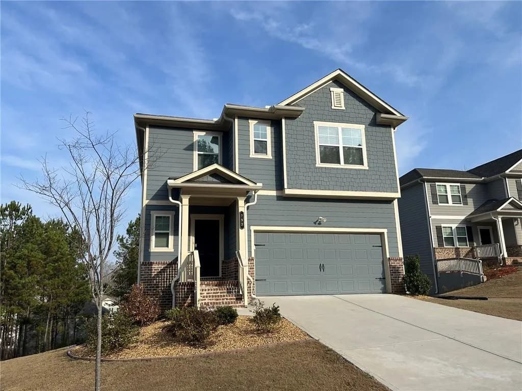Craftsman house featuring driveway, an attached garage, and brick siding